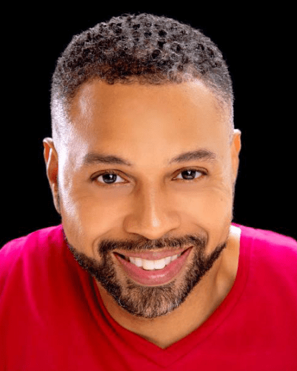 A man with a beard and mustache wearing a red shirt.